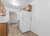 Thumbnail 31 of 35 - a kitchen with a white refrigerator and wooden cabinets