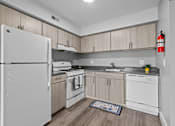 Thumbnail 5 of 50 - A kitchen with white appliances and wooden cabinets.