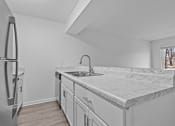 Thumbnail 5 of 41 - a kitchen with marble counter tops and a stainless steel refrigerator