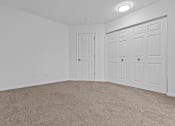 Thumbnail 17 of 41 - an empty bedroom with white doors and carpeting