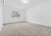 Thumbnail 18 of 38 - a bedroom with white walls and carpet