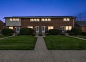 Thumbnail 23 of 32 - the front of a brick house at night with lit up windows