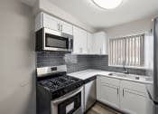 Thumbnail 5 of 32 - an empty kitchen with black appliances and white cabinets