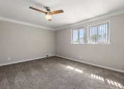 Thumbnail 20 of 32 - an empty room with a ceiling fan and two windows