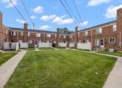 Thumbnail 26 of 32 - an image of a large brick building with a yard in front