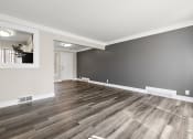 Thumbnail 12 of 32 - an empty living room with wood flooring and gray walls
