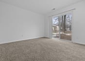 Thumbnail 26 of 41 - an empty living room with a sliding glass door to a yard