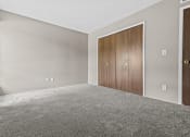 Thumbnail 27 of 35 - a bedroom with grey carpet and a wooden door