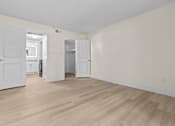 Thumbnail 11 of 116 - A room with white walls and wooden flooring with a door and a cabinet.