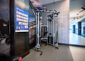 Thumbnail 22 of 31 - a fitness room with weights and machines in the corner