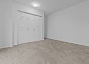 Thumbnail 16 of 41 - an empty bedroom with white doors and carpeting