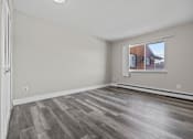 Thumbnail 13 of 26 - A room with a window and a wooden floor.