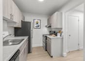 Thumbnail 1 of 33 - A kitchen with black appliances and white cabinets.