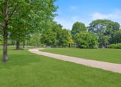 Thumbnail 44 of 46 - a path through a park with green grass and trees at Lafayette Park Place, Detroit, 48207