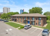 Thumbnail 43 of 46 - a brick apartment building with a lawn and cars parked in front of it at Lafayette Park Place, Detroit, MI