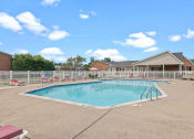 Thumbnail 18 of 35 - a swimming pool with chaise lounge chairs and a house in the background
