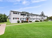 Thumbnail 27 of 33 - the view of an apartment building with a green lawn