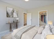 Thumbnail 20 of 38 - A bedroom with a large bed and a closet full of clothes.