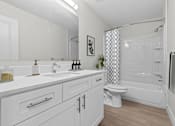 Thumbnail 6 of 14 - A white bathroom with a toilet, sink, and bathtub.