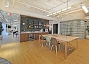 Thumbnail 23 of 38 - A modern office space with wooden floors and furniture.
