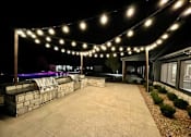 Thumbnail 33 of 39 - A patio area with lights strung above it.