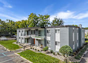 Thumbnail 28 of 28 - A modern apartment building with a parking lot in front.
