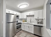 Thumbnail 15 of 28 - A modern kitchen with stainless steel appliances and white cabinets.