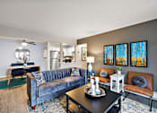 Thumbnail 2 of 28 - A living room with a blue couch and a black coffee table.