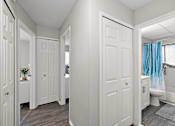 Thumbnail 24 of 28 - A white bathroom with a blue shower curtain.