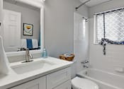 Thumbnail 21 of 28 - A white bathroom with a toilet, sink, and bathtub.