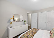 Thumbnail 22 of 28 - A white bedroom with a bed, dresser, and mirror.