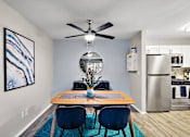 Thumbnail 4 of 28 - A dining room with a wooden table and blue chairs.