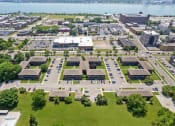 Thumbnail 37 of 46 - an aerial view of a parking lot with buildings in the background and a body of water in at Lafayette Park Place, Detroit, MI, Detroit, Michigan