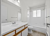 Thumbnail 5 of 26 - A white bathroom with a sink, toilet, and bathtub.