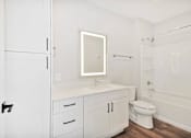 Thumbnail 30 of 38 - A white bathroom with a toilet, sink, and bathtub.
