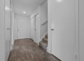 Thumbnail 10 of 47 - the landing of a staircase in a home with white walls and wood floors at Edge At Farmington Hills - Farmington Hills, MI, Michigan, 48334