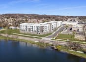 Thumbnail 41 of 51 - A large white building sits next to a body of water.