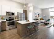 Thumbnail 22 of 58 - A modern kitchen with a large island and a view of the outdoors.