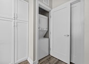Thumbnail 31 of 58 - A white cabinet with a door open revealing a white dishwasher and washing machine.
