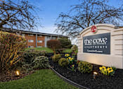Thumbnail 33 of 35 - The Cove Apartments is a residential complex with a well-maintained garden in front.