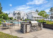 Thumbnail 68 of 87 - Outdoor grilling station and pool area at Village Club of Farmington Hills Apartments, Michigan, 48331