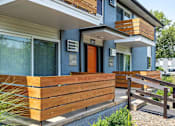 Thumbnail 3 of 28 - A blue house with a wooden fence in front.