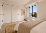 Thumbnail 14 of 30 - A bedroom with a large bed and a window overlooking a residential area. at Park On Canal Apartments - Clinton Twp, MI Apartments, Clinton Twp, 48038