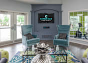 Thumbnail 32 of 43 - A living room with a sofa, armchair, and coffee table.