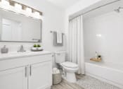 Thumbnail 4 of 29 - A white bathroom with a toilet, sink, and bathtub.