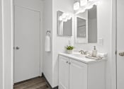 Thumbnail 9 of 35 - A white bathroom with a white sink and a white door.