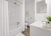 Thumbnail 10 of 35 - A white bathroom with a tub, toilet, and sink.