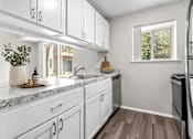 Thumbnail 2 of 35 - A kitchen with white cabinets and a marble countertop.