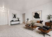 Thumbnail 6 of 23 - A modern living room with a white couch, a coffee table, and a chair.