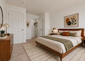 Thumbnail 10 of 23 - A bedroom with a large bed and a painting above it.